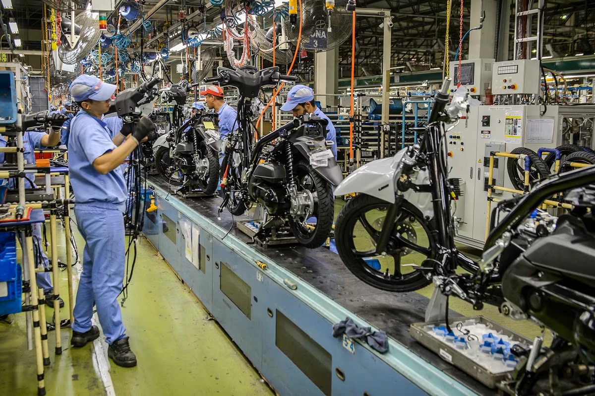 Linha de montagem de motos em fábrica moderna com iluminação industrial e tons azulados